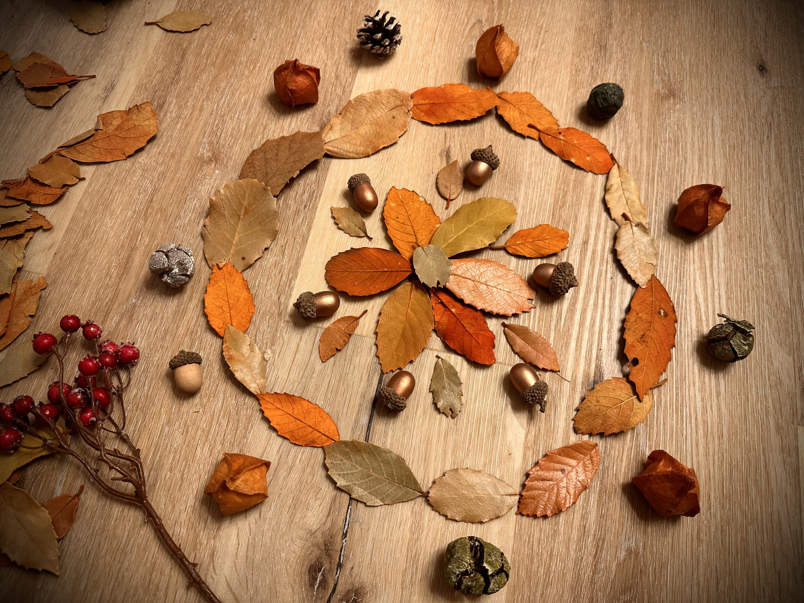 Aus bunten Herbstblättern und Eicheln gelegte Spirale im Musikraum