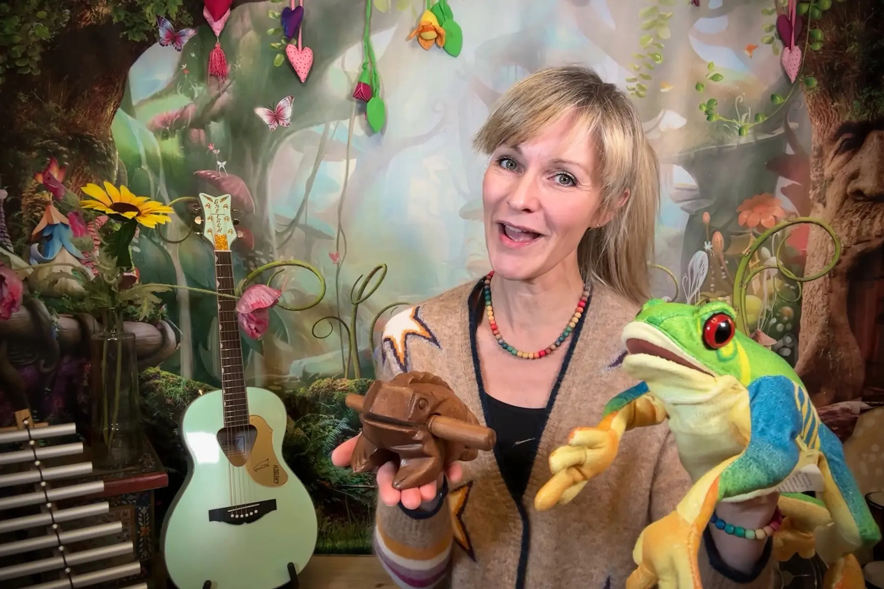 Nadine Ortkemper mit Frosch-Handpuppe, Holzfrosch und Instrumenten in der Musikwerkstatt