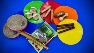 Orff-Instrumente und Bildkarten vom Wald auf bunten Sitzkissen drapiert