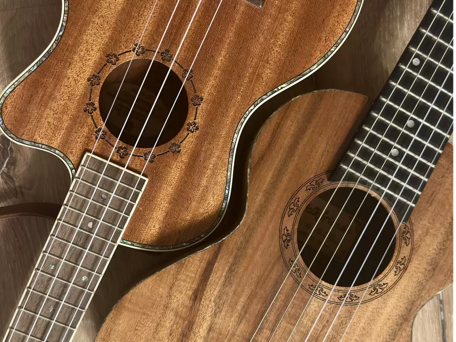 Zwei Ukulelen aus Holz auf einem Holzboden